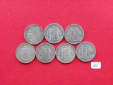 six pièces d'argent de tailles et de formes différentes sur un fond rouge