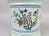 un vase blanc orné d'un oiseau et de fleurs
