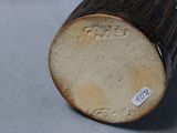 a close up of a brown vase with a tag on it