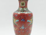un vase rouge orné d'un motif floral