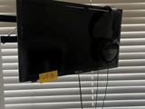 une télévision à écran plat accrochée au mur près d'une fenêtre