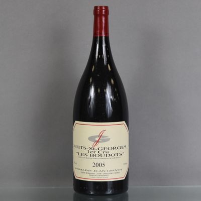 a bottle of red wine sitting on top of a glass table