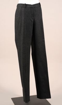 le pantalon est noir et gris, avec une chemise blanche, présenté sur un mannequin