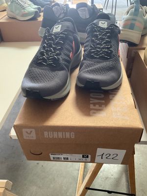 pair of black running shoes sitting on top of a box in a store