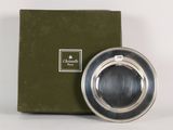 a silver plate that is sitting in front of a green box