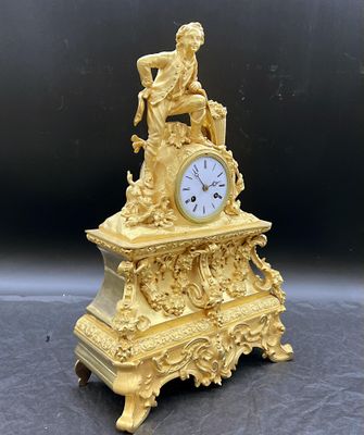 une horloge en or surmontée d'une statue