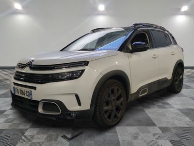 un SUV Citrole blanc garé dans une pièce au sol en damier