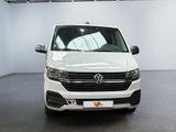 the front view of a white vw transport van parked in a garage