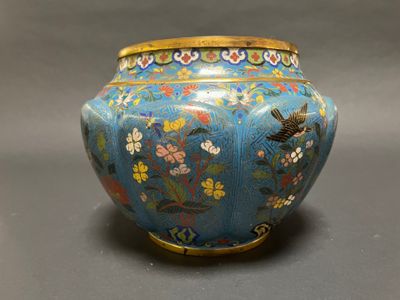 a blue vase with flowers and birds painted on it