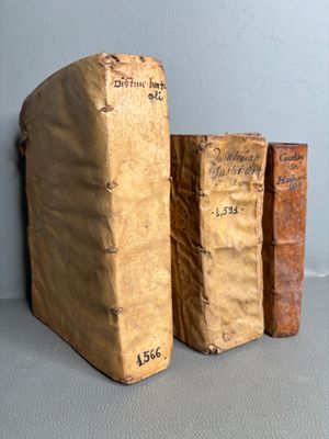 three old books sitting on top of a table next to each other