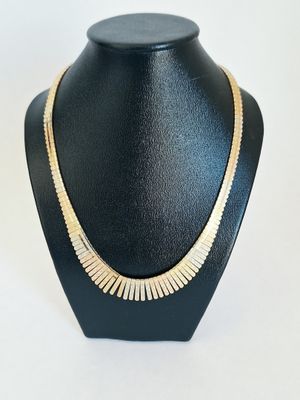 a black mannequin with a gold necklace on it