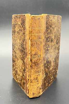 an old book sitting on top of a table next to a black table