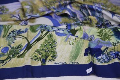 a close up of a bed with a blue and green floral comforter