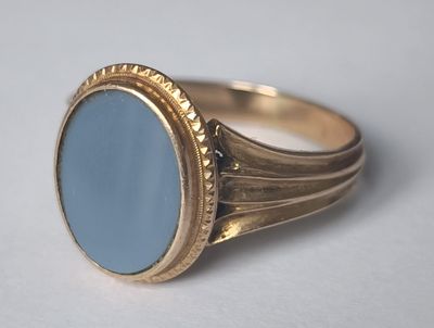 Gros plan sur une bague en or ornée d'une pierre bleue