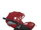 une poussette rouge à pois avec un guidon noir