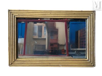 reflet d'un bâtiment dans un miroir posé sur un mur blanc