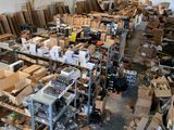 une grande pièce remplie de cartons, empilés les uns sur les autres sur des étagères
