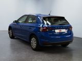 the rear end of a blue car in a white room