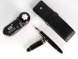 le stylo se trouve à côté d'un étui à stylos et d'un stylo posé sur une surface blanche