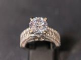 a close up of a diamond ring on a black surface