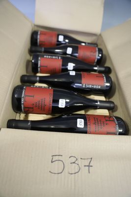 six bottles of wine are in a cardboard box on a table