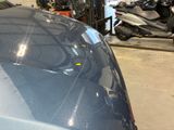 a blue car parked in a garage next to a motorcycle