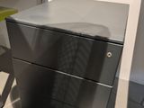 a metal cabinet and a chair in a room