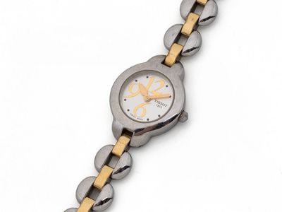 a close up of a watch on a white surface with a yellow band