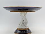 a white and blue plate with a statue on top of it