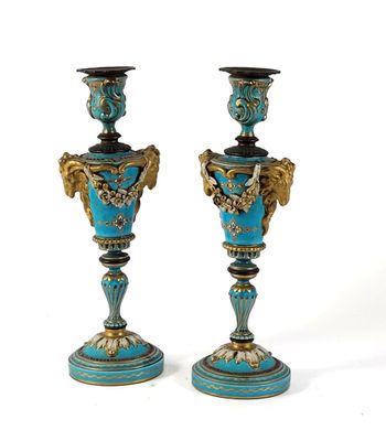 pair of blue and gold vases on pedestals against a white background