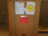 a cardboard box with a sign on it in the middle of a room