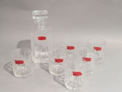 six verres et une carafe posés sur une table