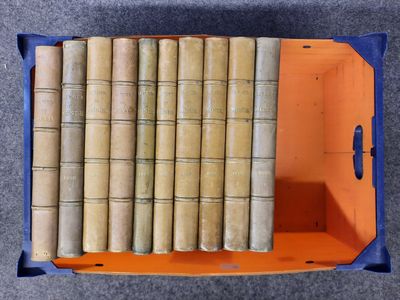 de nombreux livres anciens dans une boîte bleue posée par terre
