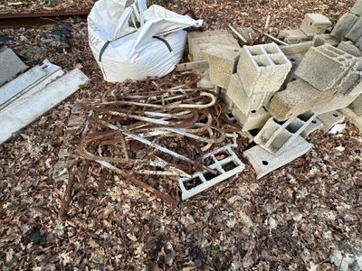 un tas de parpaings et un sac de briques posés par terre
