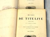 trois livres ouverts posés sur une table l'un à côté de l'autre