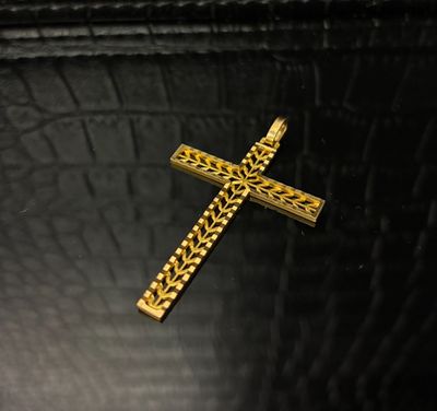 une croix en or posée sur une table noire