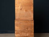 an old wooden chest of drawers against a black wall