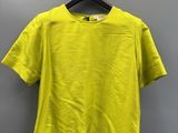 a yellow t - shirt hanging on a hanger in a room