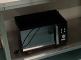 un micro-ondes posé sur une étagère dans la cuisine