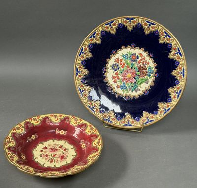 two plates with floral designs on them sitting on a table