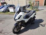 une moto blanche et noire garée sur un parking