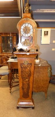 une horloge posée sur un socle au milieu d'une pièce
