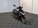 un scooter garé sur un sol à damier