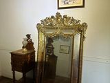 a mirror and a table in a room with a painting on the wall