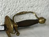 a small sword that is laying on a white surface