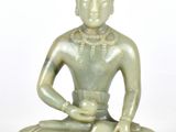 une statue représentant une personne assise en position du lotus