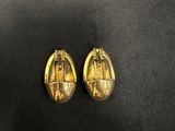 a pair of gold earrings with a picture of a woman on it