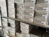 boxes of electronic equipment are stacked on a shelf in a warehouse