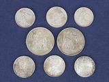 six pièces d'argent sont disposées en cercle sur un fond bleu