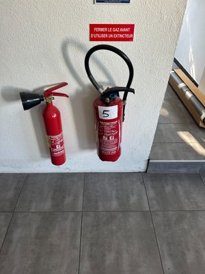 un extincteur et un autre extincteur accroché au mur